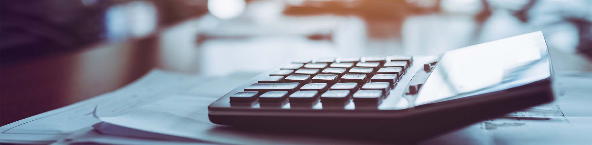 calculator on stack of papers on conference room table