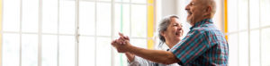 Aged couple dancing in living room