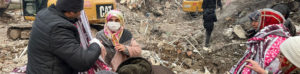 Volunteers handing out blankets to others in the midst of earthquake destruction.