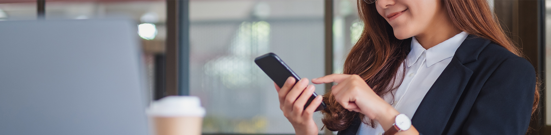 woman at a desk smiling at her phone