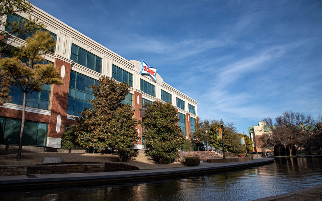 A multi-story modern building with large windows and brick walls.